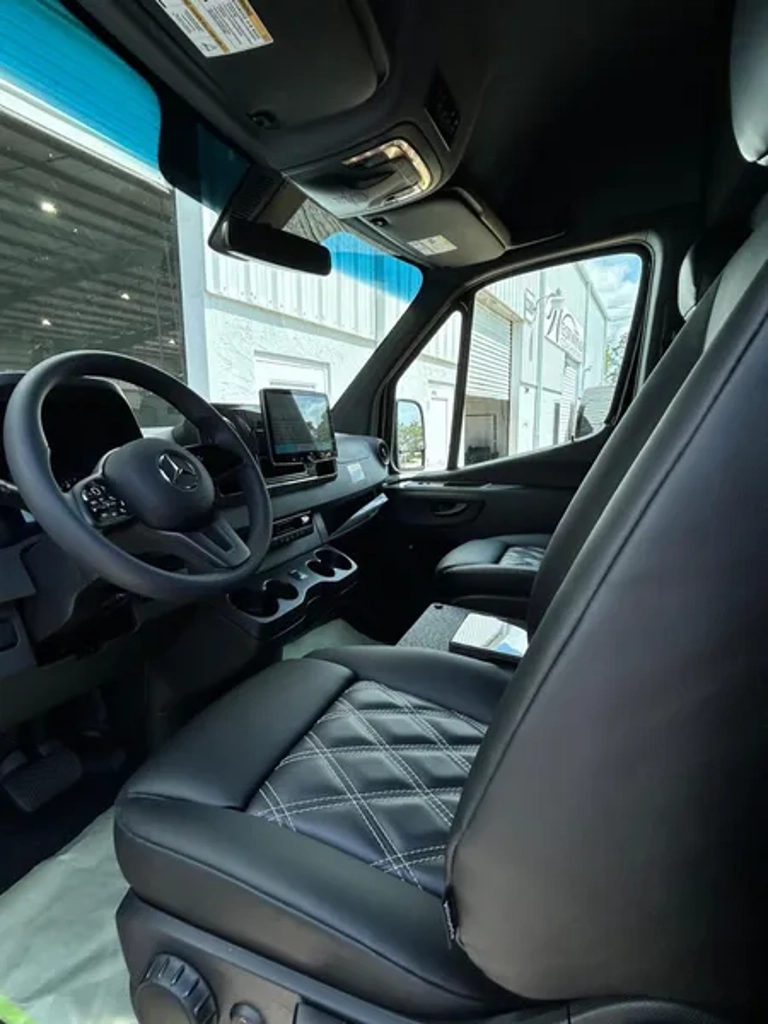 Mercedes-Benz Sprinter van front cabin with leather steering wheel, touchscreen display, and quilted leather captain's seat