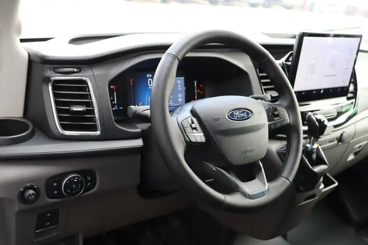 Ford van dashboard with digital instrument cluster, leather steering wheel with controls, and a touchscreen infotainment display