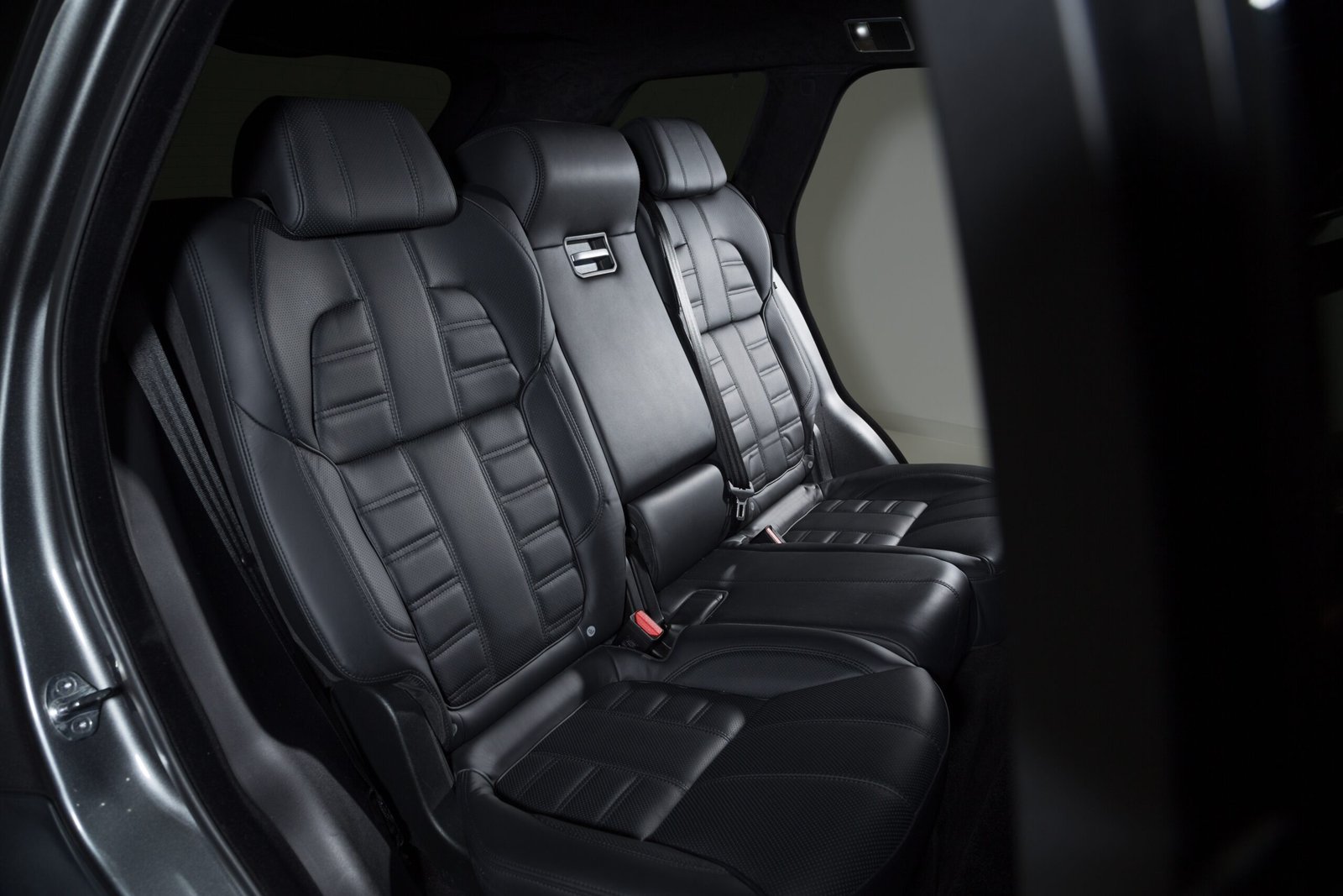 Rear bench seat with black leather upholstery and fold-down center armrest