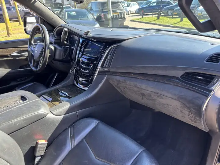 Cadillac Escalade dashboard with leather steering wheel, center touchscreen, and black leather seating