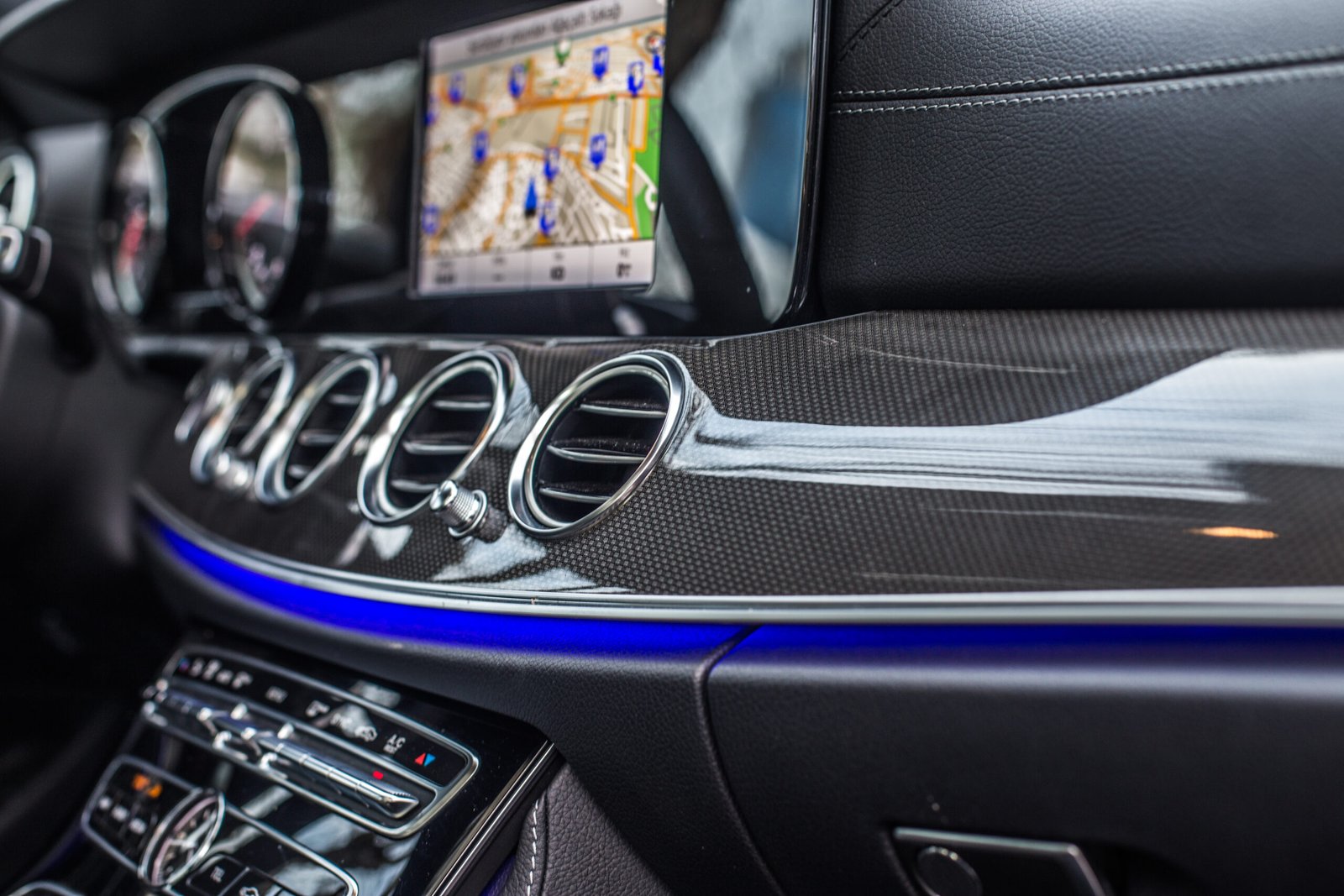 Mercedes-Benz E-Class dashboard with GPS navigation screen and ambient blue lighting