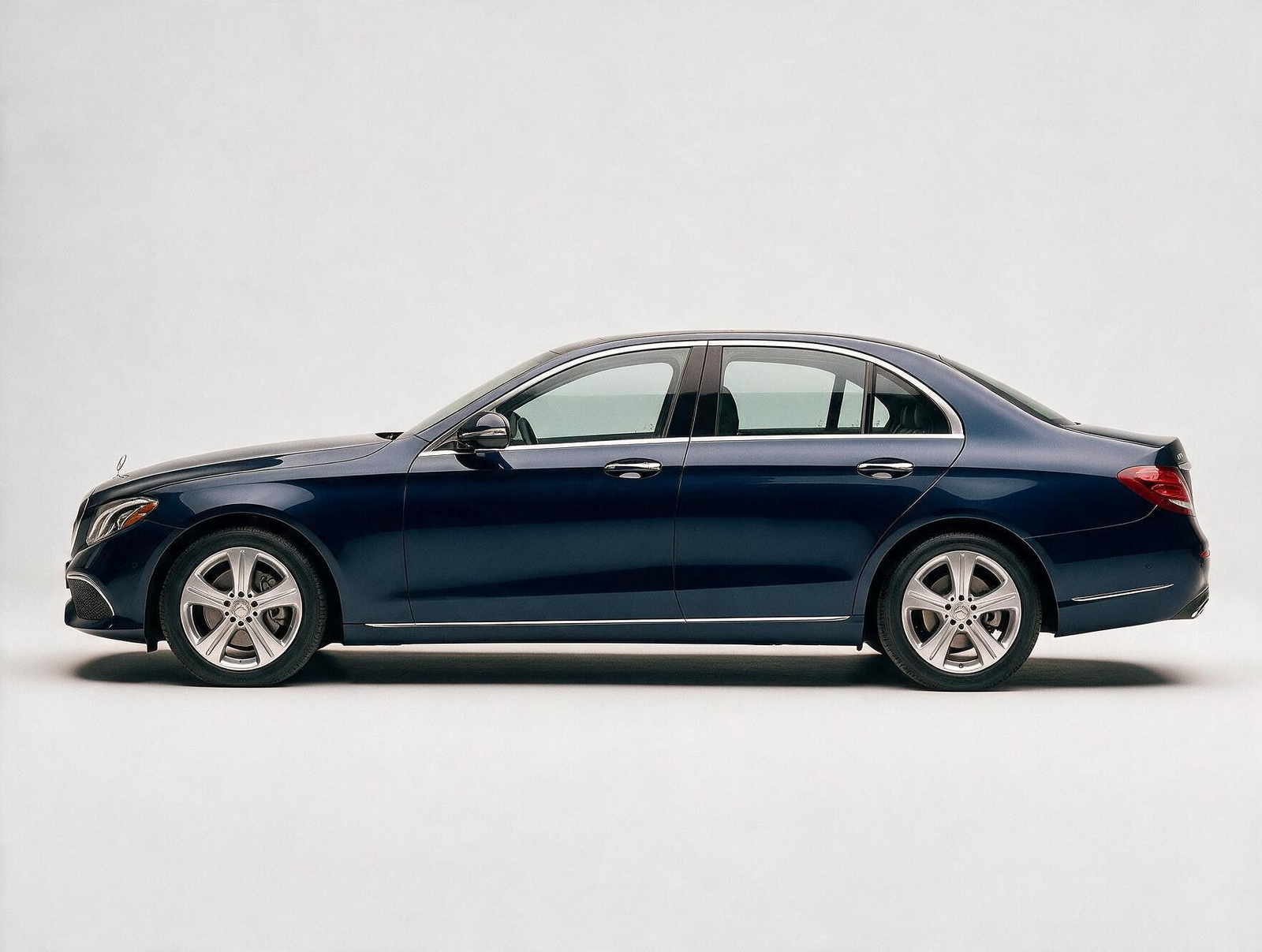 Dark blue Mercedes-Benz E-Class sedan side profile on white background